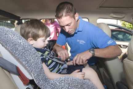 Sean helping child into safety seat